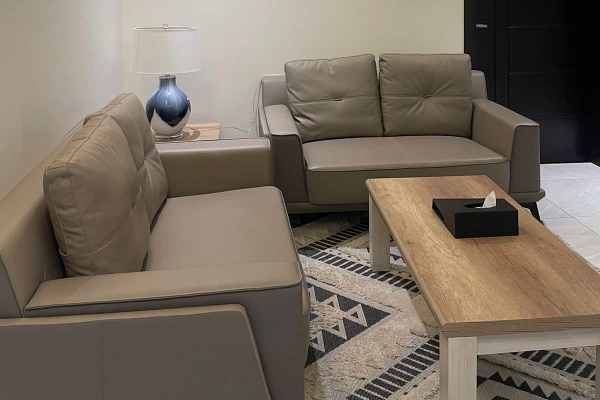Ein modernes Wohnzimmer mit einer Couch, einem Couchtisch und zwei Bildern an der Wand.