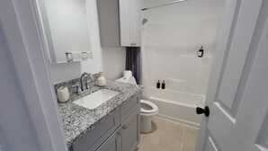 Een badkamer met een wastafel, toilet en bad.