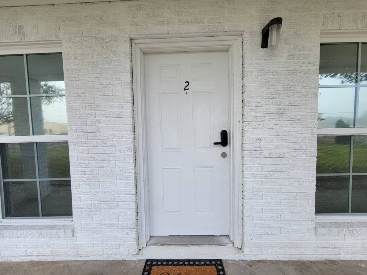 A white door with the number 2, a black door handle, and a small window to the left.
