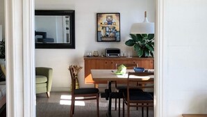 A dining area with a wooden table, chairs, a plant, and a painting on the wall. - 7 Person Holiday Home in Fiska (Vanylven)