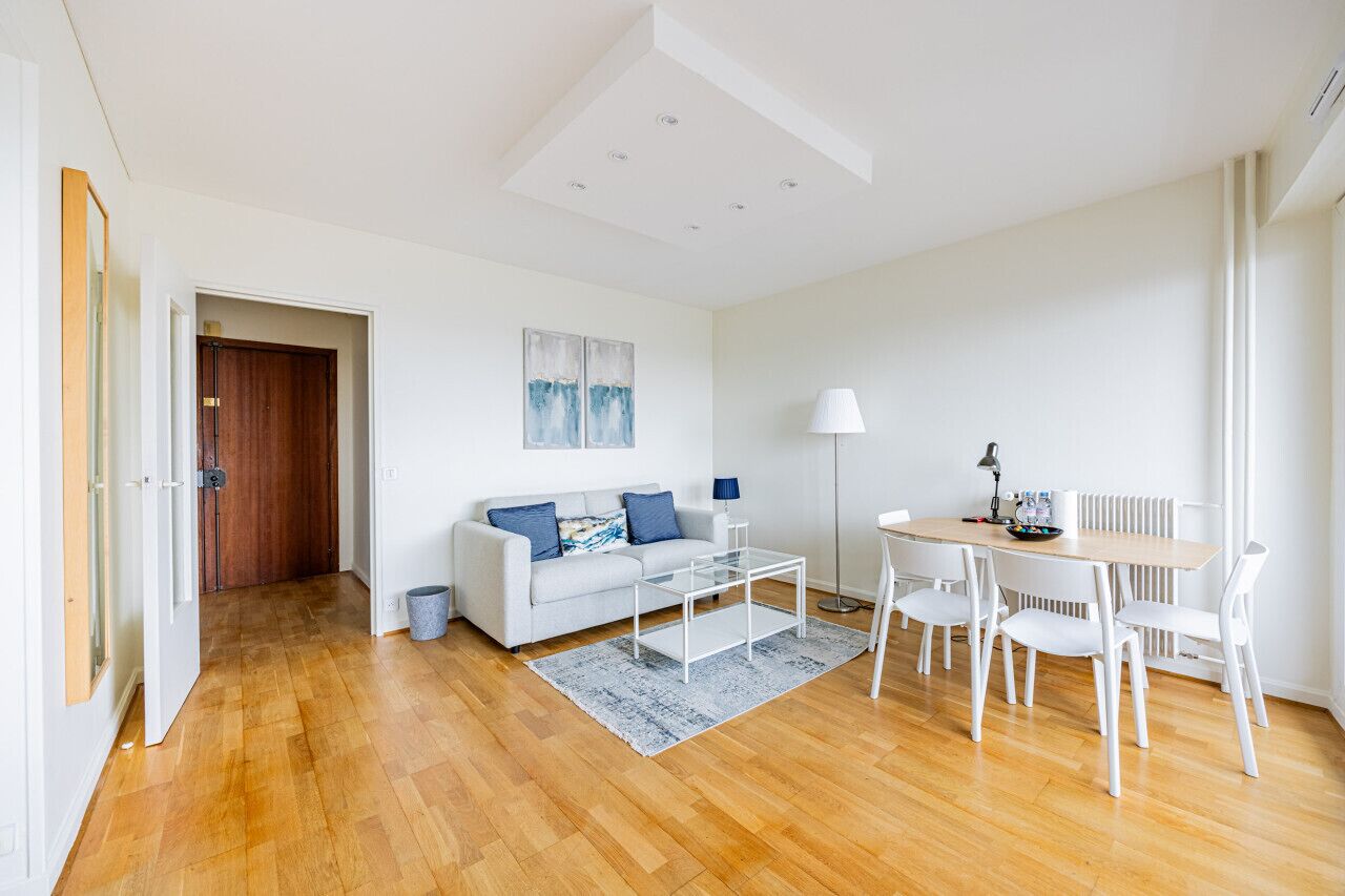 Una sala moderna con sofá, mesa de centro y comedor.