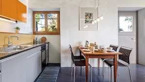 Une cuisine moderne dotée d’un four encastré, d’un évier et d’un coin repas avec une table et des chaises.