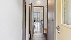 Un couloir étroit, avec une porte sur le côté droit donnant accès à un balcon avec vue.