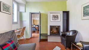 Un salon moderne doté d’une cheminée, d’un coin repas et offrant une vue sur la cuisine.