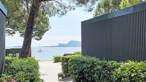 Un chemin menant à un bâtiment moderne, offrant une vue sur la mer et les montagnes.
