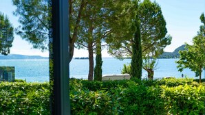 Une vue d’un lac, avec des arbres et un bateau au premier plan.