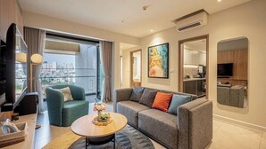 A modern living room with a sofa, a coffee table, and a TV. - LuSSO Suites - D1mension & Zenity Tower (Ho Chi Minh City)