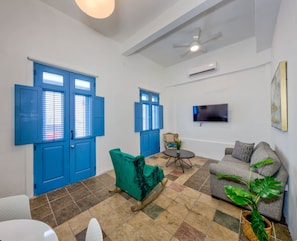 Relax in this stylish living room with a large window, flat-screen TV, and comfortable sofas.