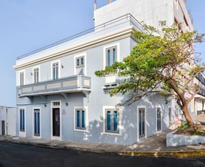 Stunning two-story building with a balcony and tree-lined street view.