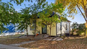 A single-story house with a front porch, a small tree, and a mailbox. - Downtown Retreat - Cozy Home Near Iconic Downtown (Fargo)