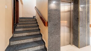 A staircase with a handrail leading to an elevator. - Treebo Premium Zorba - Hoshangabad Road (Bhopal)