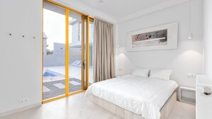 A modern bedroom with a large bed, sliding glass doors to a balcony, and a minimalist decor. - 3BR Luxury Villa in Tbilisi (shindisi)