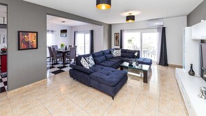 A modern living room with a sectional sofa, a glass coffee table, and pendant lighting. - Exquisite Spacious Villa Bufaline With Pool and Gym (Kastela)