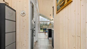 A wooden interior with a kitchen area, including cabinets and a refrigerator. - 2 bedroom gorgeous home in Kalundborg (Kalundborg)