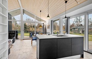 A modern kitchen with a large island, large windows, and a view of the outdoors. - 2 bedroom gorgeous home in Kalundborg (Kalundborg)