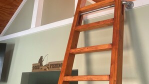A wooden ladder leaning against a wall with a sign that reads "GONE FISHING" and a letter "O" sign below it. - Broyles Landing Cottage at Lake Hartwell SC (Townville)