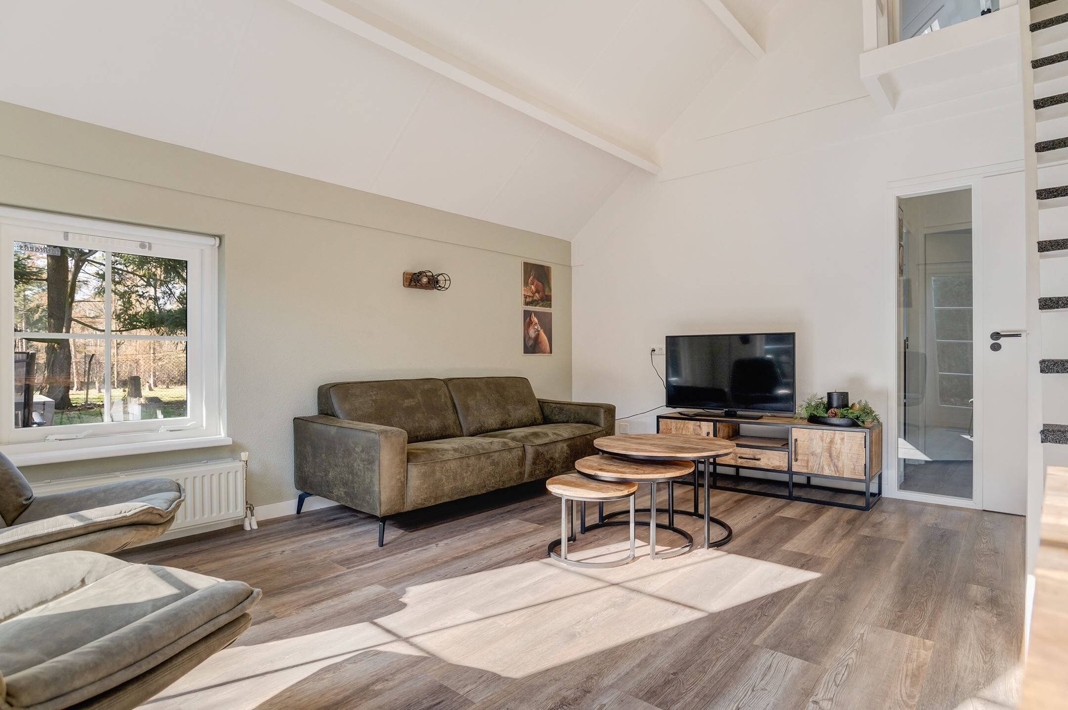 Una sala de estar moderna con sofá, mesa de centro y televisor.