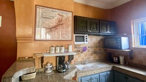 A kitchen with granite countertops, a map on the wall, and a microwave. - Apartment with distant ocean view, sleeps 4/6 (Essaouira)