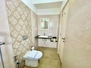 Une petite salle de bain comprenant des toilettes, un lavabo et une douche.