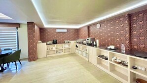 Une cuisine moderne avec un mur de crédence décoré d’un motif en briques, un coin repas avec une table et des chaises, et un meuble intégré contenant des ustensiles de cuisine.