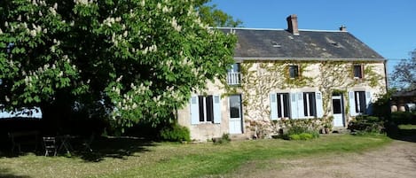 A two-story house with a sloped roof and a chimney.
