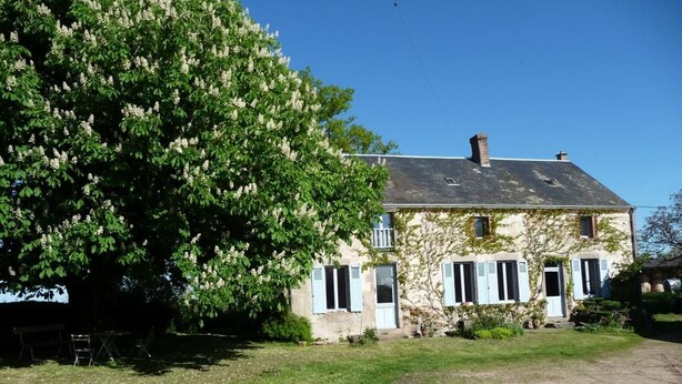 A two-story house with a sloped roof and a chimney. - Comfortable rooms on a farm in the heart of Berry (Montchevrier)