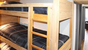 A bunk bed with a wooden frame and black bedding. - Renovated studio for 5, near lifts, balcony (Les Orres)