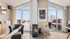 A cozy living room with a fireplace, a sofa, and a dining area.
