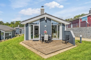 A modern house with a deck, large windows, and a chimney. - Waldpalast - Comfortable Vacation Home for 4 to 6 People with a Sauna   (St. Andreasberg)