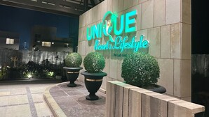 En hotelindgang med et skilt, der siger "UNIQUE Resort & Lifestyle".