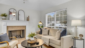 Un salon avec une cheminée, un canapé, une table basse et une lampe.