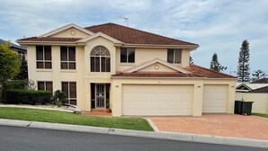 A two-story house with a garage, a driveway, and a well-maintained lawn.