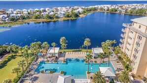 Un resort con una piscina grande, palmeras y vista al océano.