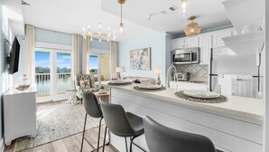 Una cocina moderna con una isla grande, taburetes de bar y vistas al exterior.