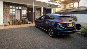 Una casa moderna con un SUV blu parcheggiato nel vialetto.