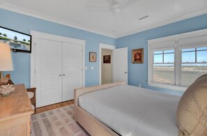 Ein Schlafzimmer mit Bett, Schreibtisch, Stuhl, Fernseher und einem Fenster mit Aussicht.