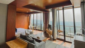 A modern hotel room with a wooden ceiling, large windows, a balcony, and a kitchenette. - Damar Langit Resort (Cisarua)