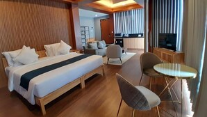 A hotel room with a large bed, a desk, a chair, and a television. - Damar Langit Resort (Cisarua)