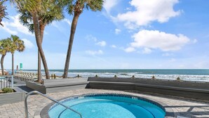 A pool area with a view of the ocean, palm trees, and a sign indicating a 3ft depth limit. - Garden City Beach Oceanfront Condo 508 | Rising Tides Properties Rental (Murrells Inlet)