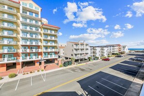Un hôtel à plusieurs étages doté de balcons, d’un parking et offrant une vue dégagée sur l’océan.