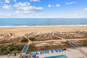 Ein Strandresort mit Pool, Liegestühlen und Blick auf den Ozean.