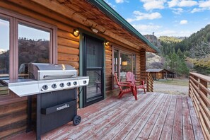 A wooden cabin with a grill and outdoor seating. - Sapphire Ridge Cabin (Hamilton)