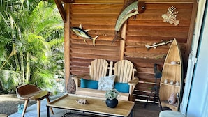 A wooden deck with a sofa, chairs, and a telescope. - Luxury villa with sea view (Les Anses-d'Arlet)