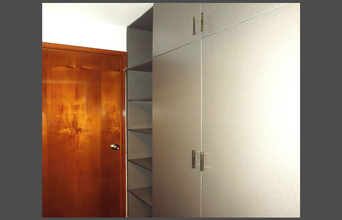 A wardrobe with a wooden door and a metallic interior.