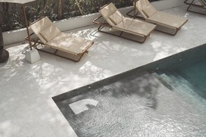 A poolside area with three lounge chairs and a small pool. - SOKO' Stay (Tabanan)