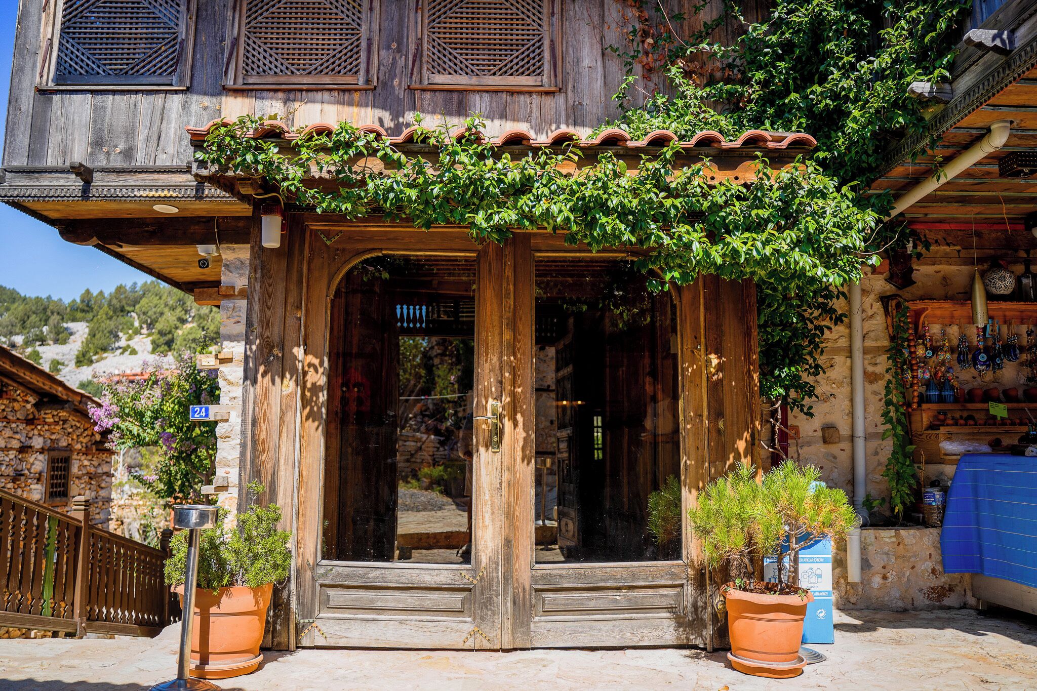 A rustic wooden building with a traditional design, featuring a wooden door and steps leading to an entrance.
