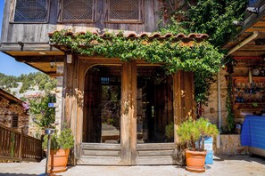 A rustic wooden building with a traditional design, featuring a wooden door and steps leading to an entrance.
