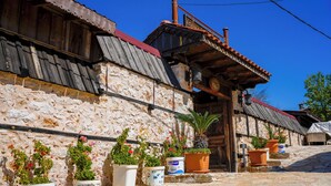 A stone building with a red-tiled roof, wooden shutters, and potted plants in front. - Ayşenaz Hanım Konağı (Akseki)