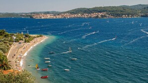 A coastal town with a beach, boats, and a hilly backdrop. - Great 3-Bedroom Apartment with Sea View (Orebic)