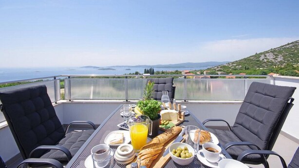 A table set with breakfast items and a scenic view of the sea. - Great 3-Bedroom Apartment with Sea View (Orebic)